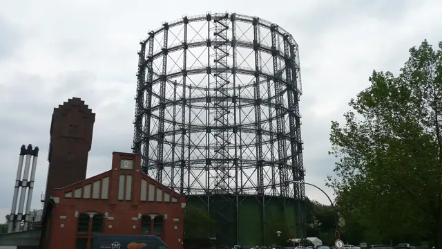 L'ancien gazomètre, vaste structure d'acier circulaire, et les bâtiments de brique du campus