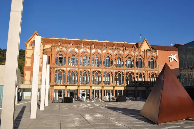 Façade de brique et de pierre du musée des sciences, sculpture d'acier sur le parvis