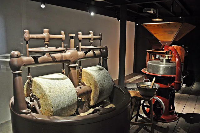 Meules de granit et torréfacteur ancien de la chocolaterie, dans l'espace d'exposition