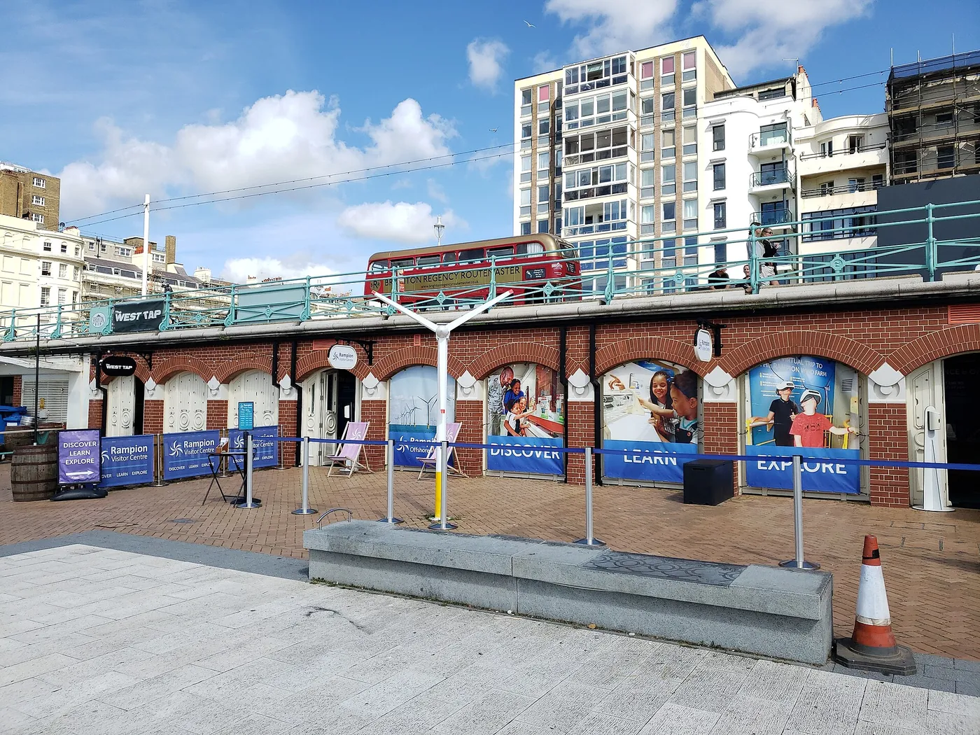 Voyage scolaire durable à Brighton : façade du centre d'interprétation sous les arches du front de mer, bannières « Discover, Learn, Explore »