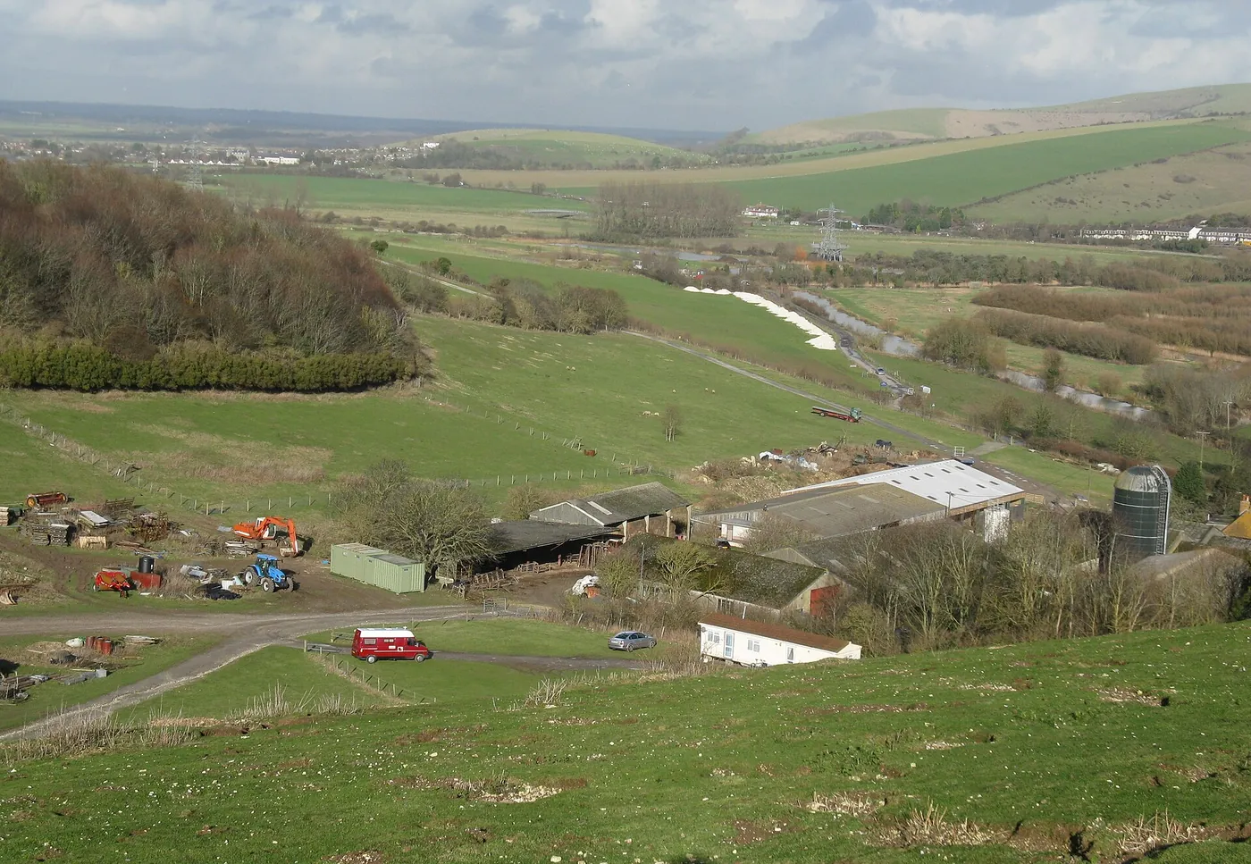 Voyage scolaire durable à Brighton : bâtiments d'une ferme au creux des collines du Sussex, vus depuis les hauteurs