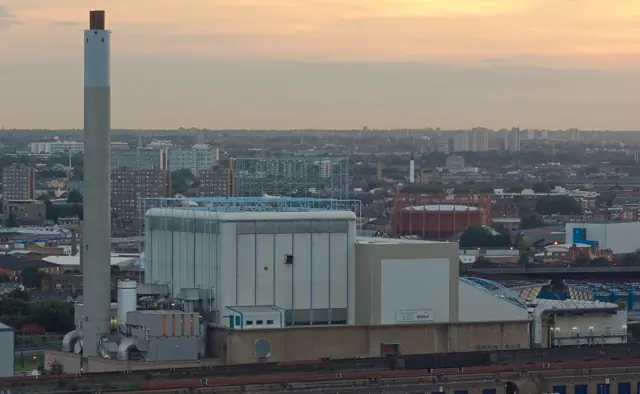 L'usine et sa haute cheminée dominant les toits de la ville