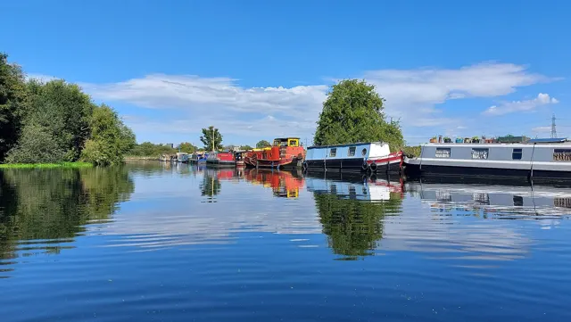 Voyage scolaire durable à Londres : péniches amarrées sur une rivière de l'est londonien, sous un ciel bleu
