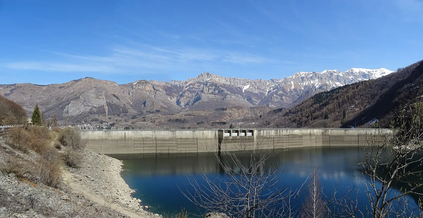 Barrage et lac de retenue au pied des montagnes enneigées, dans la vallée du Gesso