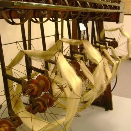 Machine ancienne de moulinage de la soie, écheveaux de soie écrue tendus entre les bobines