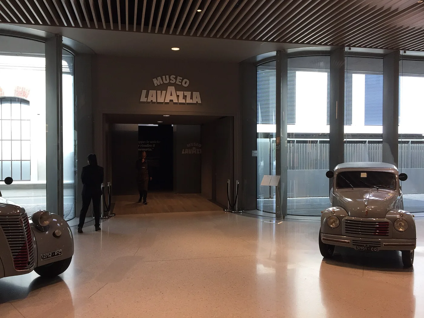 Entrée du musée d'entreprise, deux camionnettes de livraison anciennes exposées dans le hall