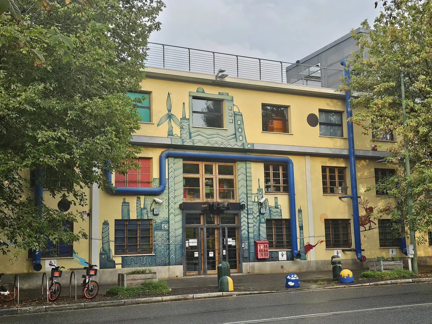 Façade d'ancienne usine peinte de motifs bleus, occupée par le musée de l'environnement