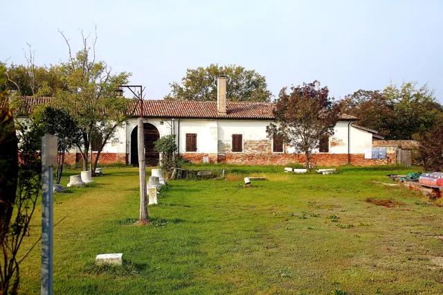 Voyage scolaire durable à Venise : bâtiment bas et pelouse plantée d'arbres sur une île de la lagune nord