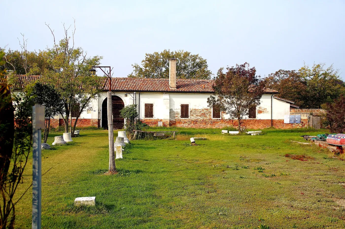 Voyage scolaire durable à Venise : bâtiment bas et pelouse plantée d'arbres sur une île de la lagune nord
