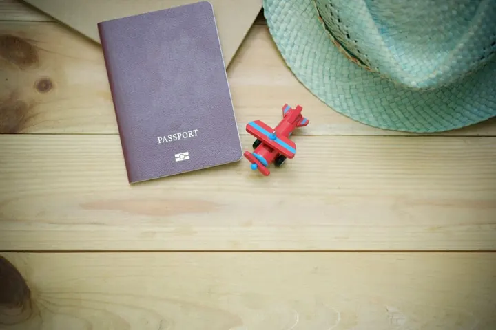 Un passeport, un chapeau de paille et un avion miniature