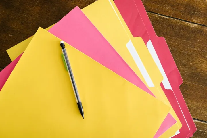 Des chemises de classement colorées et un stylo