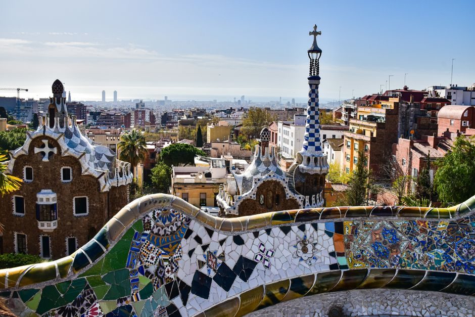 Le banc ondulé en mosaïque du Parc Güell, la ville et la mer à l'horizon