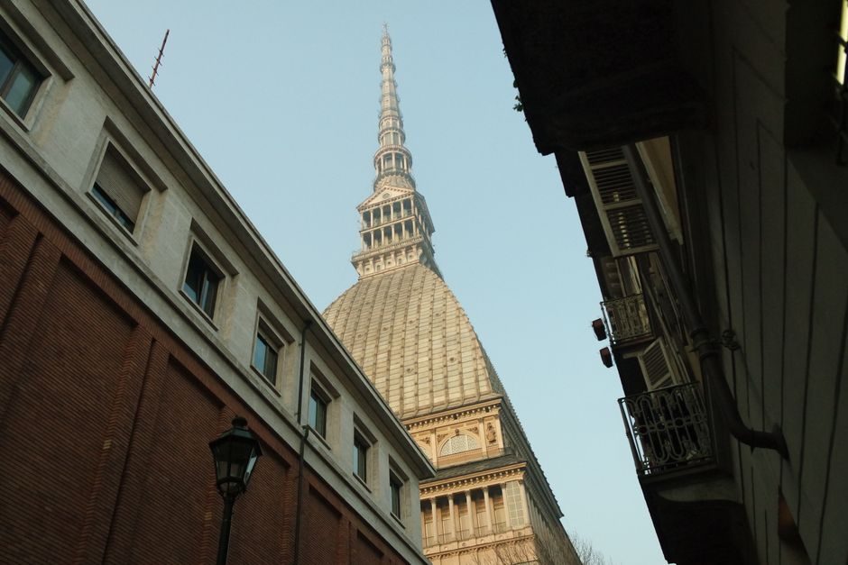 La flèche de la Mole Antonelliana encadrée par des façades