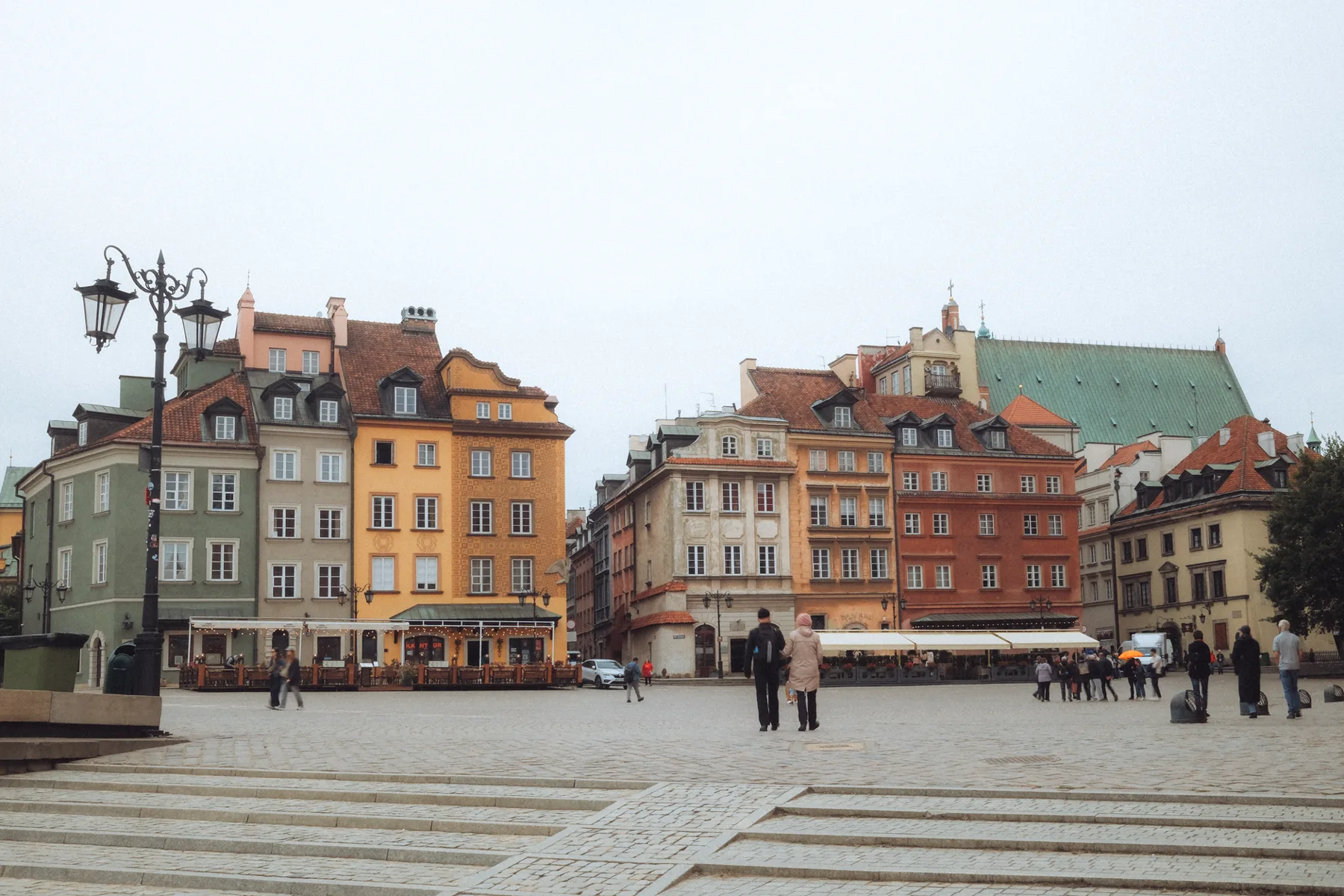 Place ancienne aux façades colorées, promeneurs sur les pavés